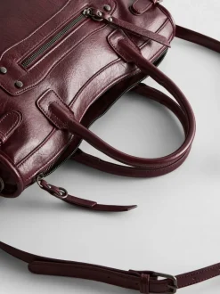 Bolso con asa superior y detalle de hebilla