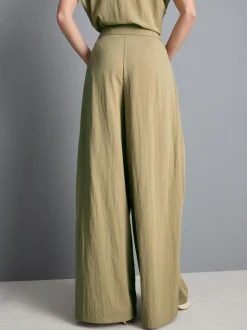 Pantalones anchos plisados con capa superpuesta