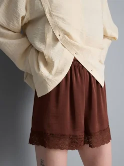 Pantalones cortos de satén con ribete de encaje