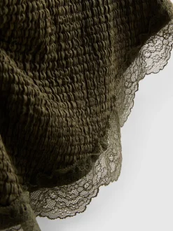 Top asimétrico texturizado con ribete de encaje